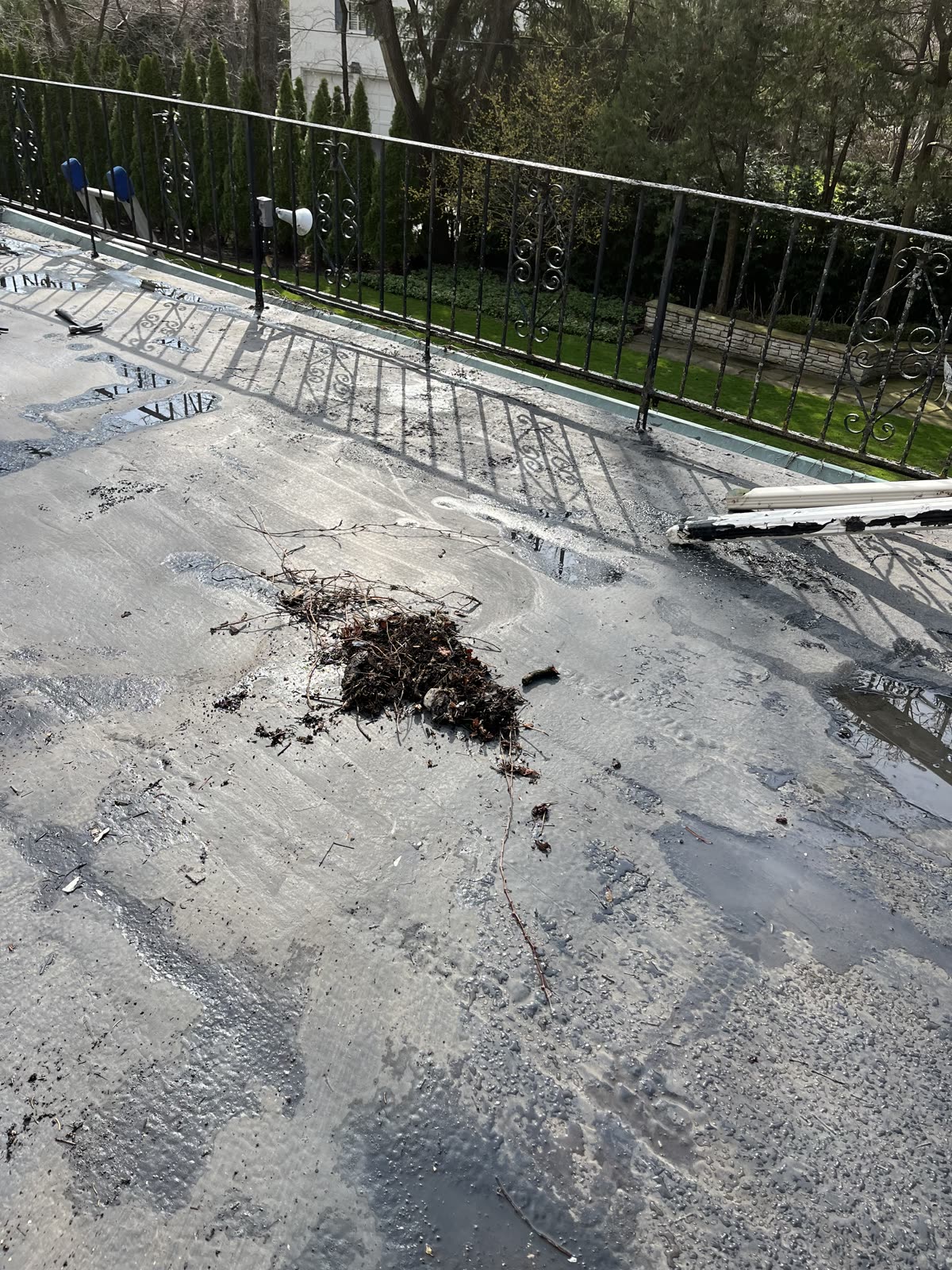 Winnetka balcony roof before repair — deteriorated surface with debris and cracking