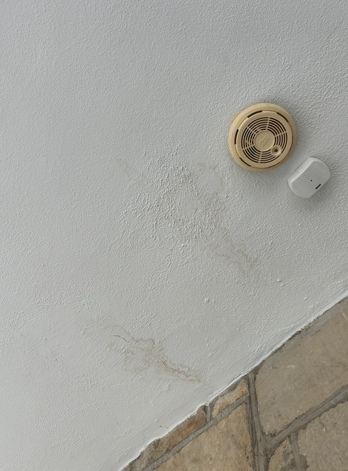 Ceiling water stain near smoke detector, Winnetka stone home interior