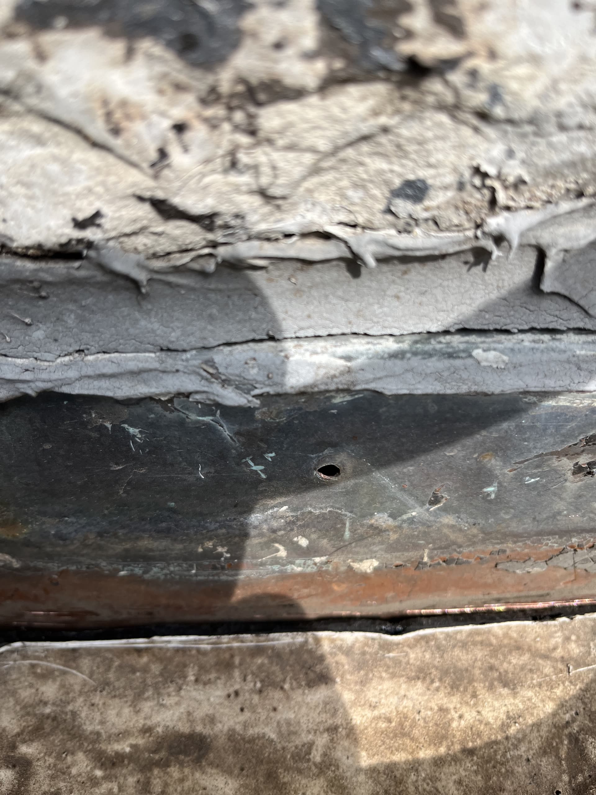 Close-up of open screw hole in flashing at wall seam, Winnetka IL
