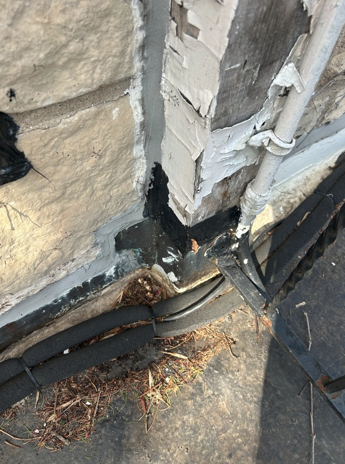 Major debris pileup at stone wall and flashing seam, Winnetka flat roof